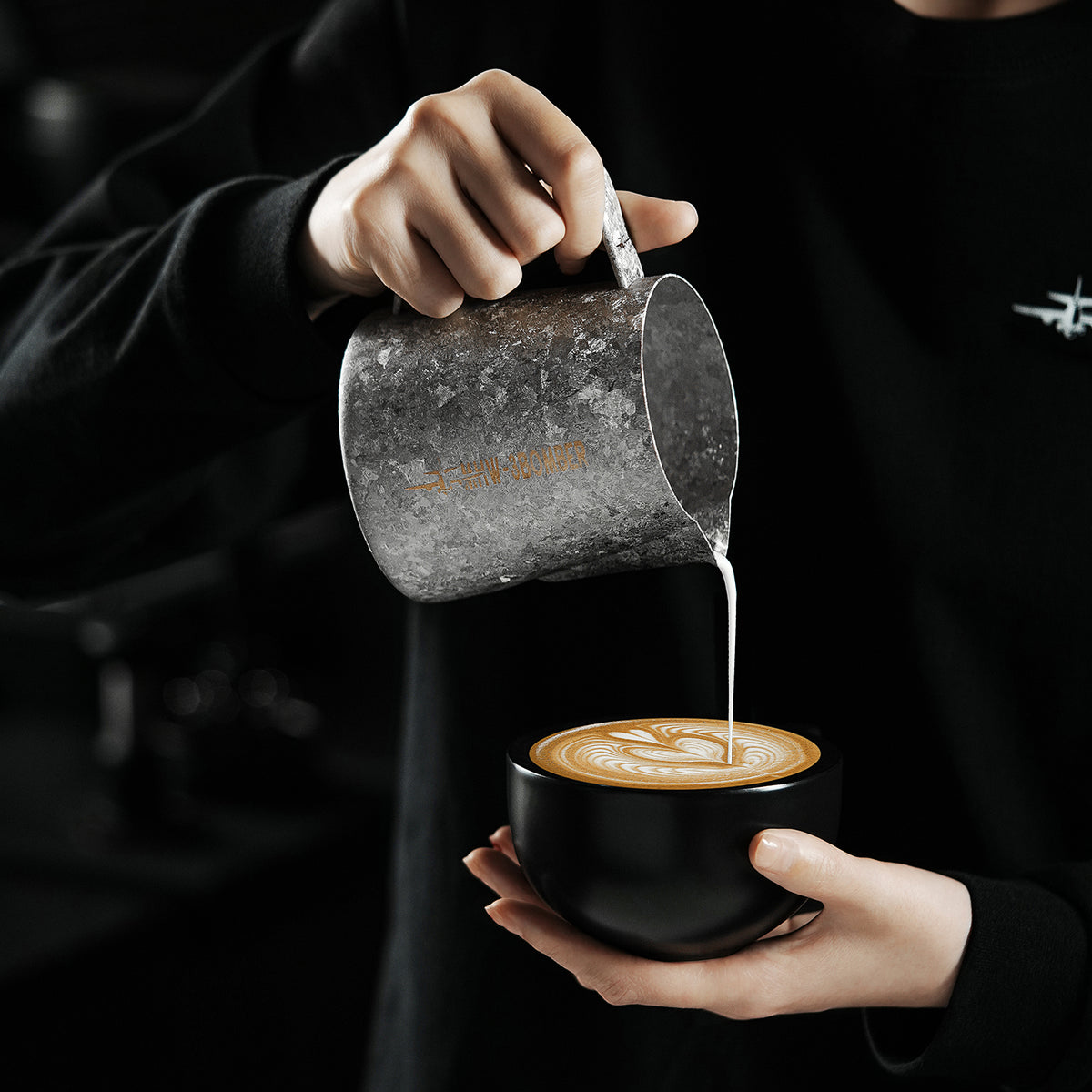 P6634 Silver Armour Titanium series 600 ml milk pitcher — pouring above a black cup. Cups and scene items are not included.