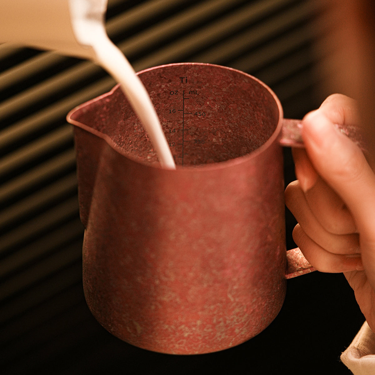 P6635R Spark Titanium series 600 ml milk pitcher — milk steaming with interior markings visible. Cups and scene items are not included.