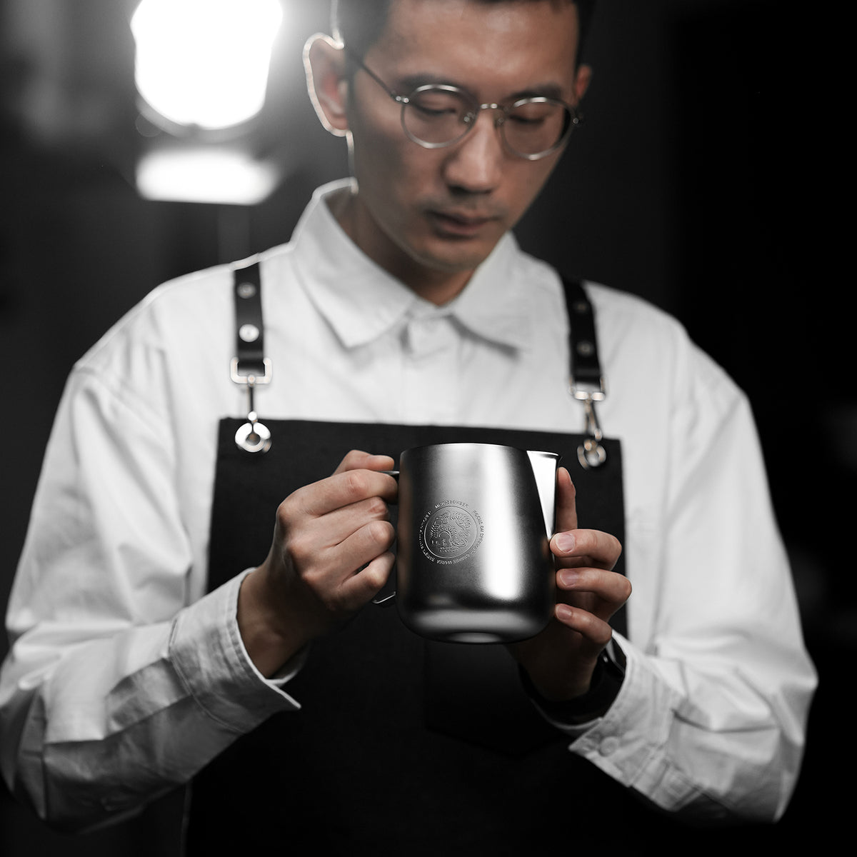 P6652S Force silver FF 650 ml milk pitcher — barista holding the pitcher