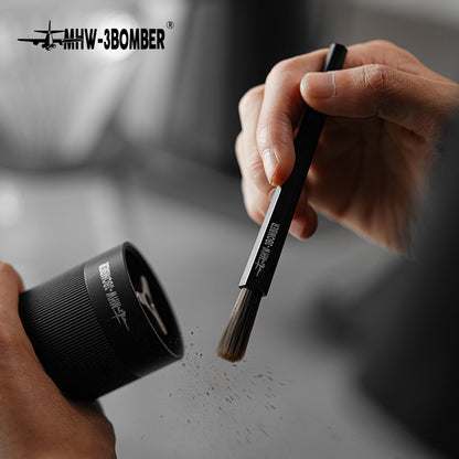 MHW-3BOMBER B5525B dark-bristle black ABS brush held beside a grinder; grinder is a scene prop