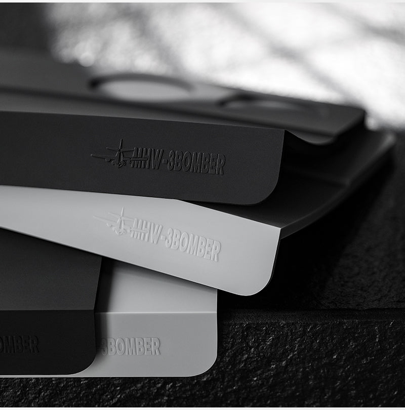MHW-3BOMBER SP5309B black B-style mat stacked above a grey comparison mat, grey mat not included