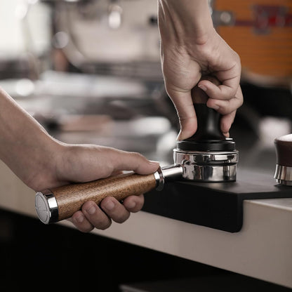 MHW-3BOMBER BP6083L walnut La Marzocco / E61 bottomless portafilter, tamping preparation; other equipment, coffee and accessories are scene props