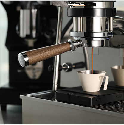 BP6083L walnut bottomless portafilter during espresso extraction on a compatible grouphead; espresso machine, cup and beverage are scene props, not included.