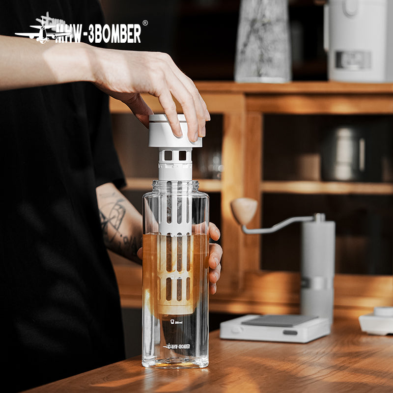 MHW-3BOMBER CE6136 White cold-brew pot with its filter being lifted from the vessel; scene tools, glasses and drink ingredients are not included.