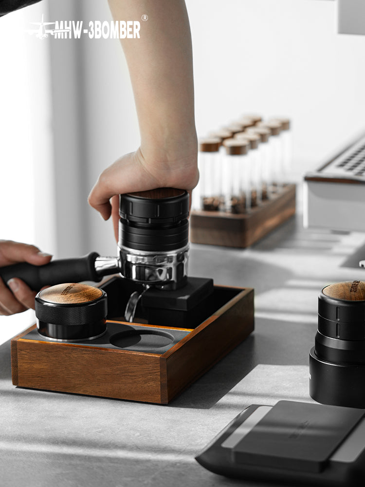MHW-3BOMBER CH5434 wood tamping platform supporting a portafilter during preparation; portafilter and dosing tools are props