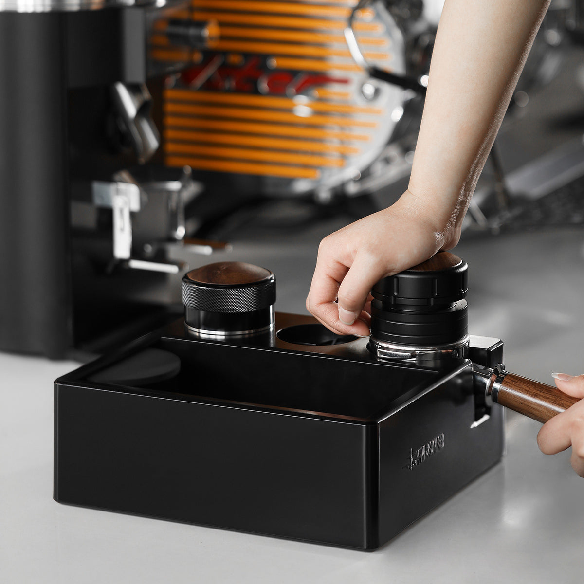 MHW-3BOMBER CH6625 in a coffee-preparation scene with a hand using a distributor; pictured portafilter, tampers and other tools are not included.