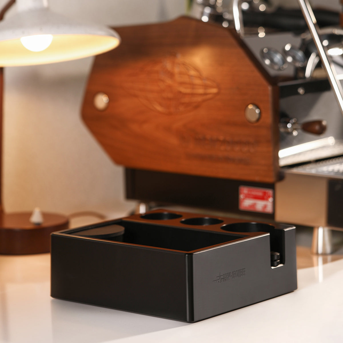 MHW-3BOMBER CH6625 beside an espresso machine with its bin visible; pictured portafilter, tampers and other tools are not included.