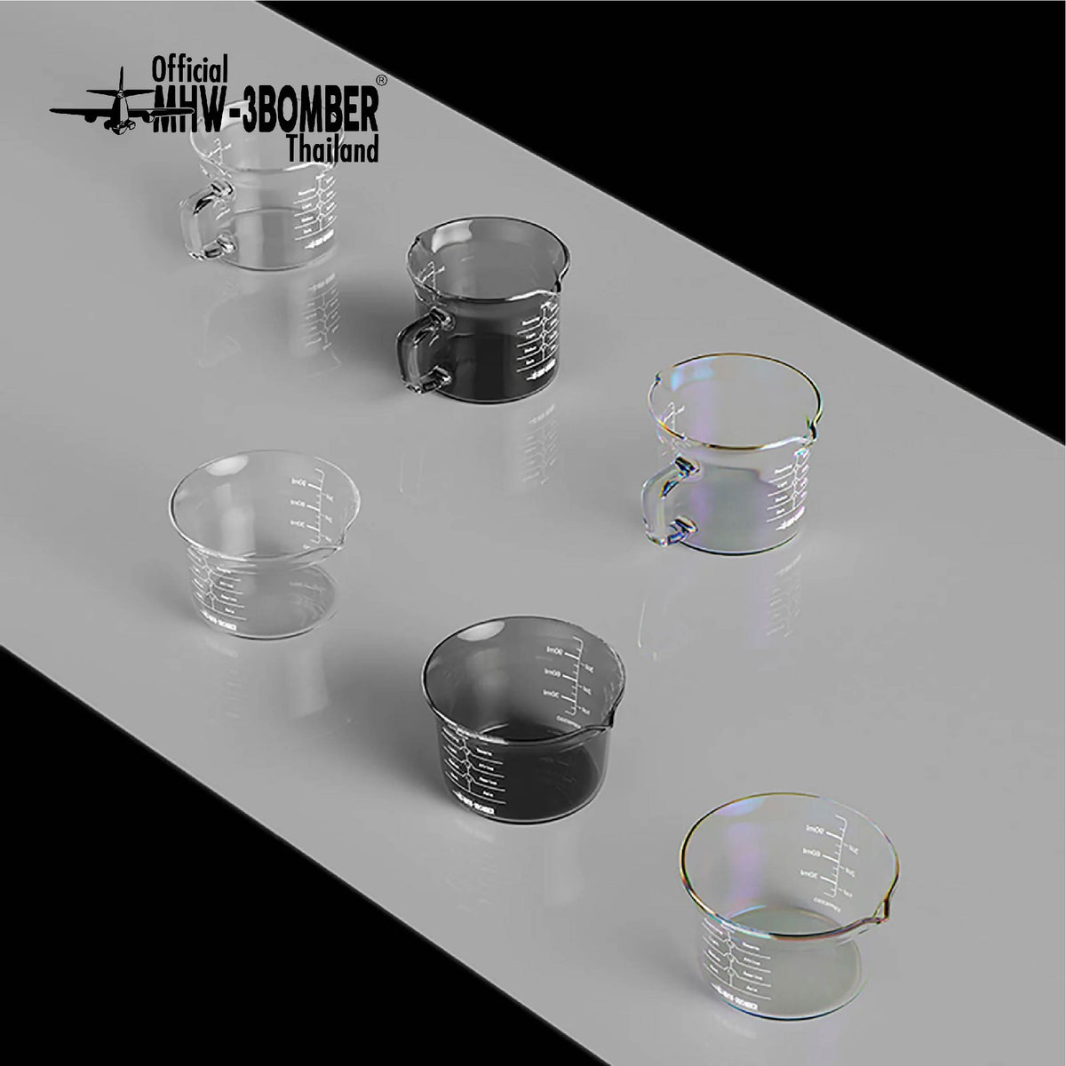 MHW-3BOMBER measuring-cup comparison: clear G5052 single-spout at front left and clear G5059 handled double-spout at back left; configurations sold separately