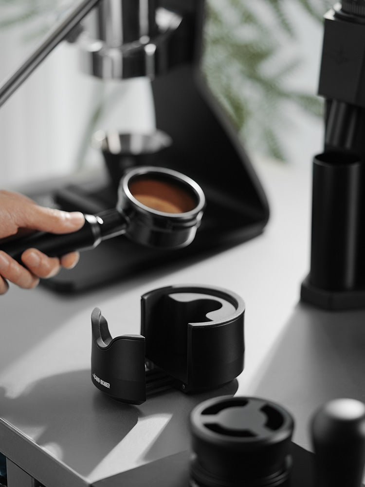 MHW-3BOMBER CT6164 black support base with extended handle support beside a held portafilter; other equipment and scene props are not included