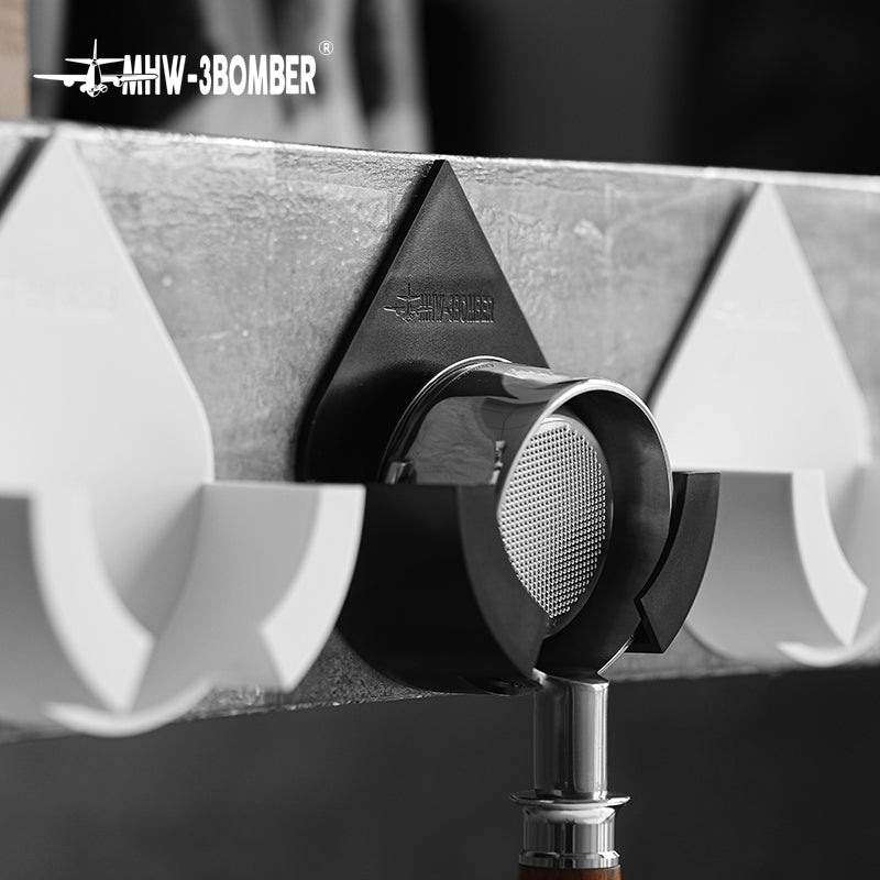 DPH5713B Black droplet holder in use on concrete wall, flanked by White family holders; White holders and portafilter not included