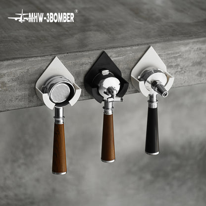 DPH5713B Black droplet holder in centre of three-holder wall display; White holders and all portafilters are reference props