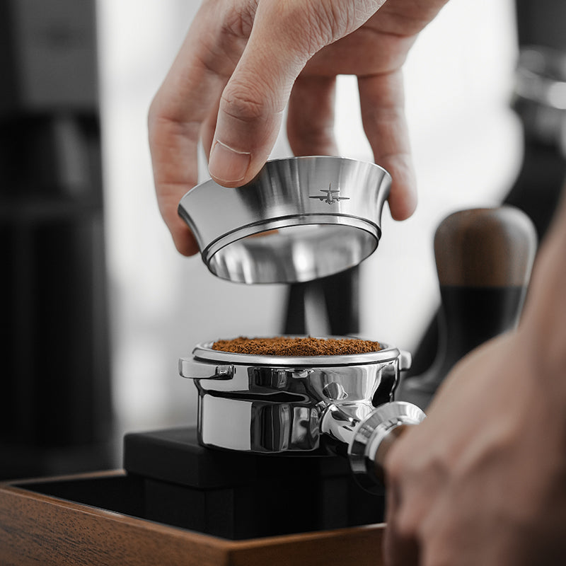 MHW-3BOMBER DR5384S silver non-magnetic steel dosing ring lifted above a filled portafilter; portafilter separate