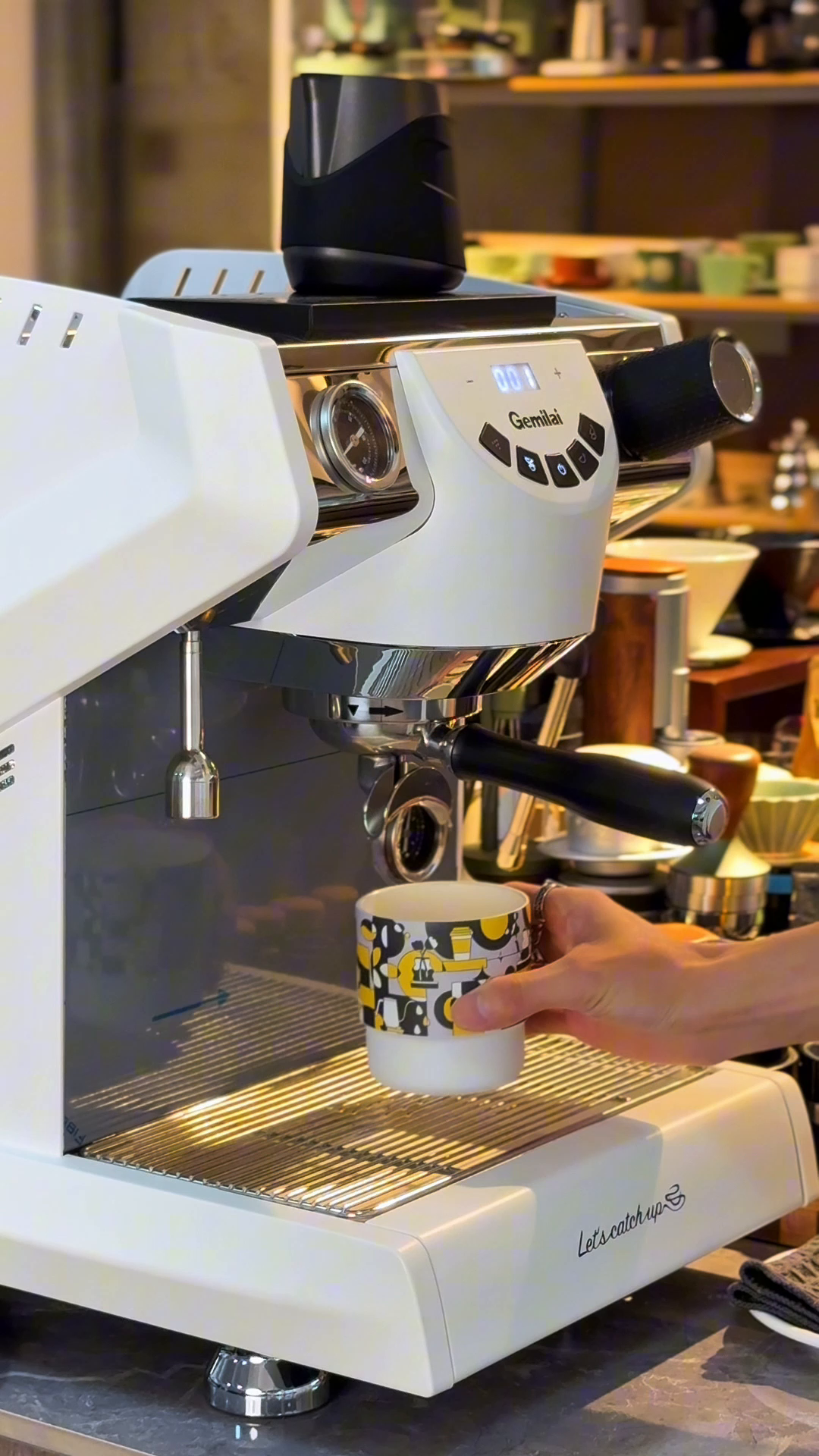 MHW-3BOMBER DW6909BY Ink Black Swirl Cup placed beneath an espresso machine