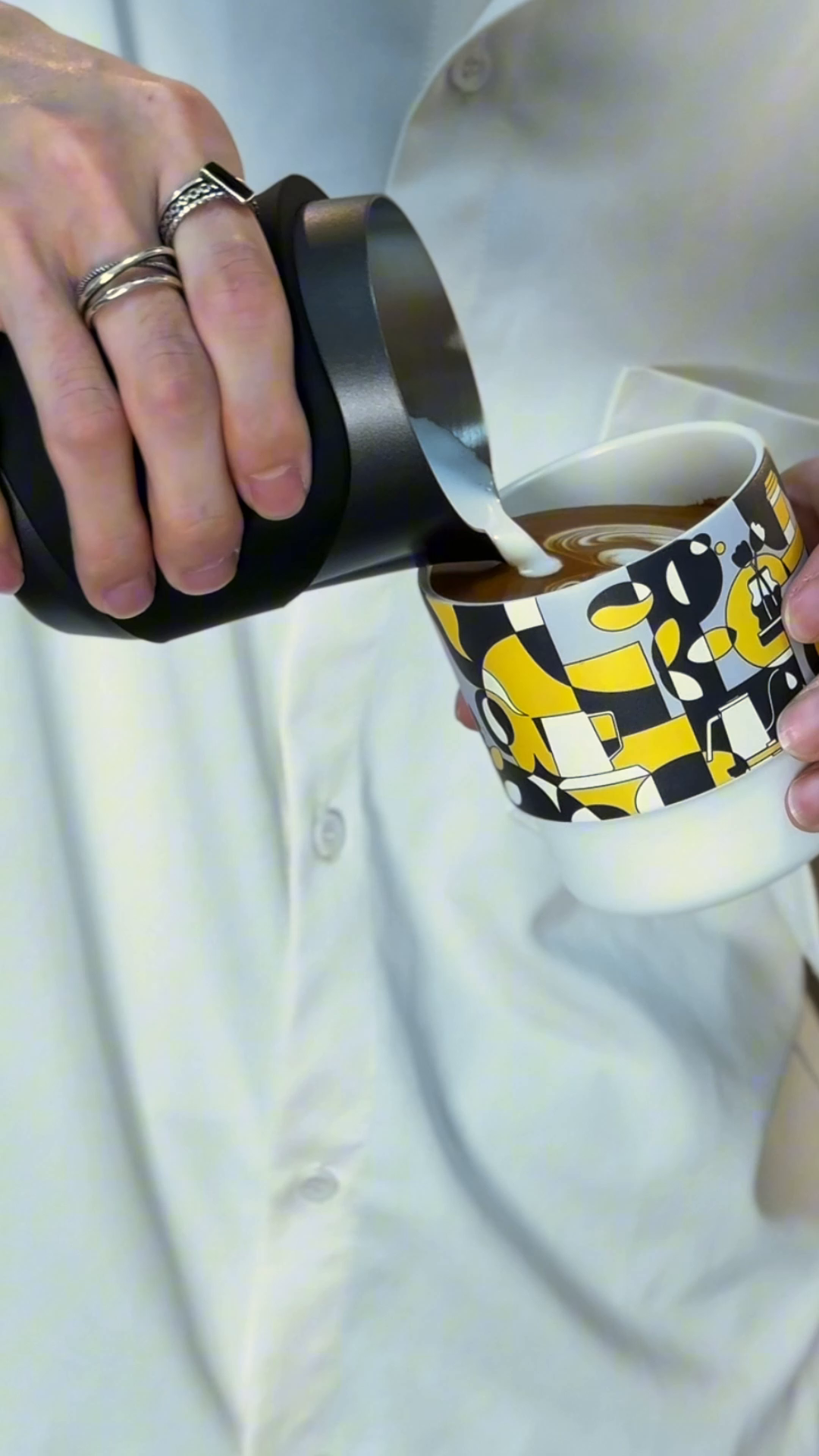 Latte art being poured into the MHW-3BOMBER DW6909BY Ink Black Swirl Cup