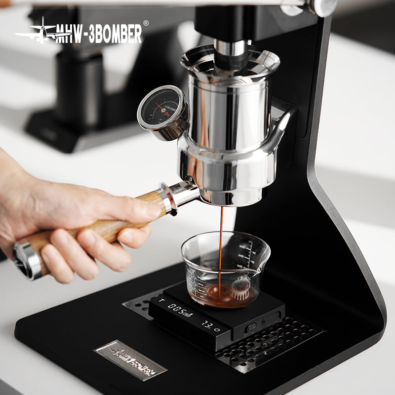 Black ES5788B Cube Coffee Scale 3.0 Micro weighing espresso in a glass on a manual espresso machine; glass and machine are props