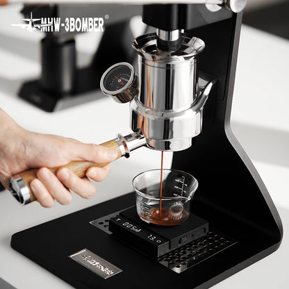 Black ES5788B Cube Coffee Scale 3.0 Micro weighing espresso in a glass on a manual espresso machine; glass and machine are props