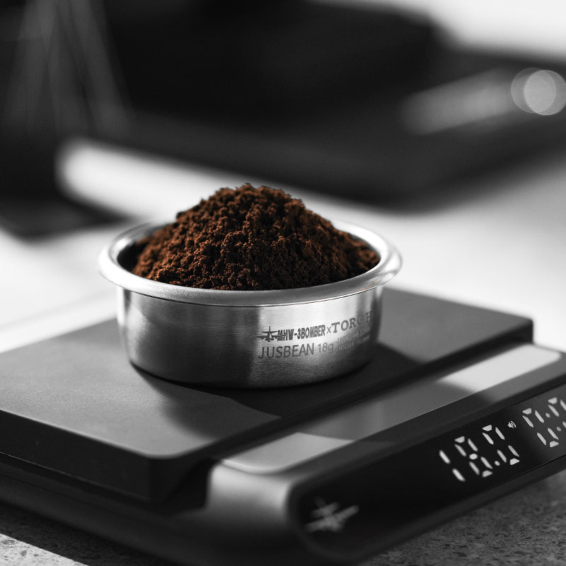 MHW-3BOMBER FB5635 silver JusBean 18 g filter basket filled with coffee grounds on a scale; scale not included