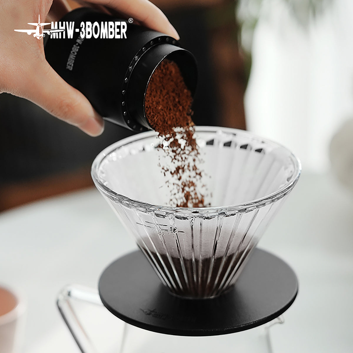 MHW-3BOMBER FC5873B Elf Glass Dripper — dosing coffee into the clear dripper with black base