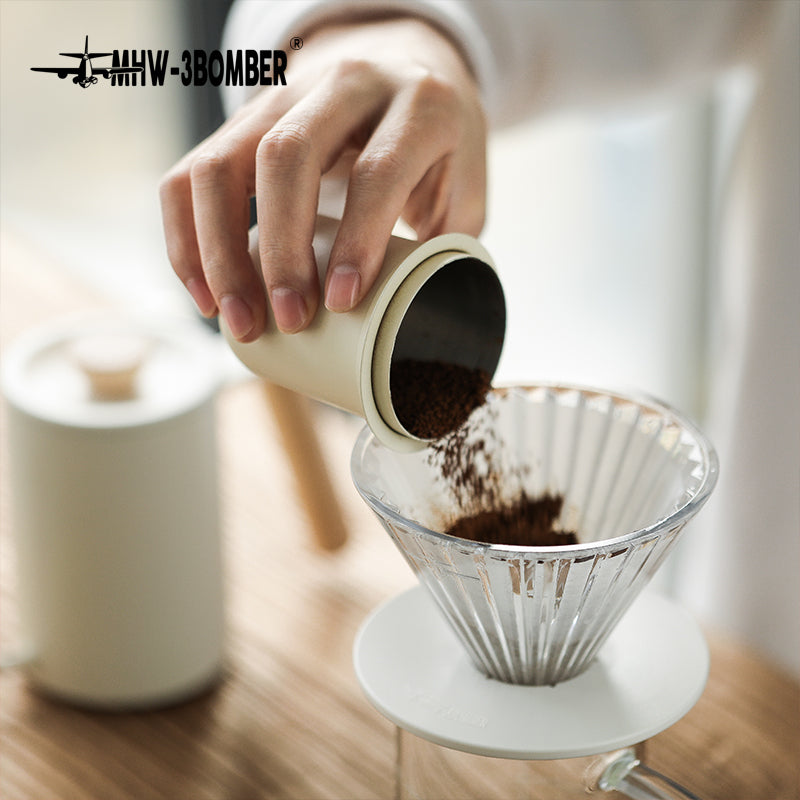 MHW-3BOMBER FC5875W Elf Glass Dripper — dosing coffee into the clear dripper with white base