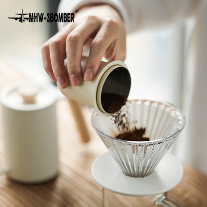 MHW-3BOMBER FC5875W Elf Glass Dripper — dosing coffee into the clear dripper with white base
