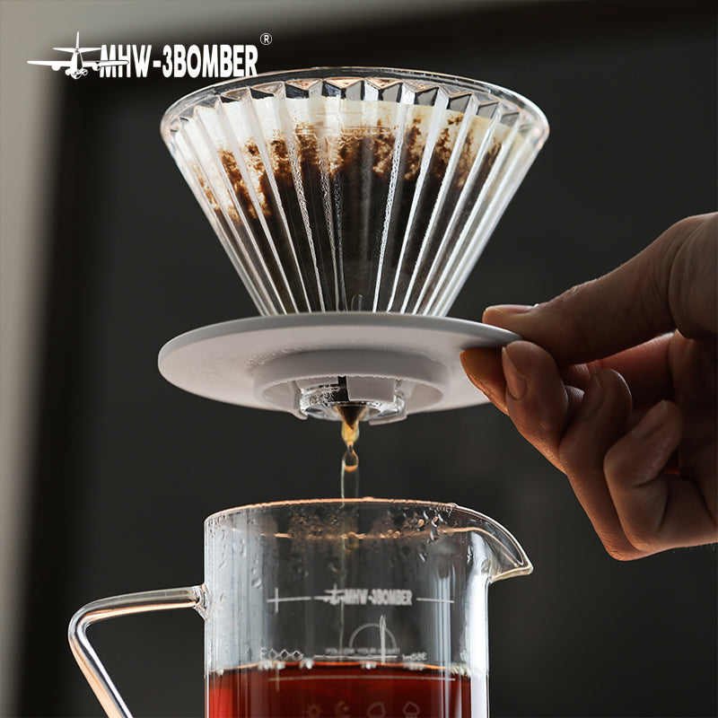 MHW-3BOMBER FC5875W Elf Glass Dripper — white base underside and brewed coffee draining into a server