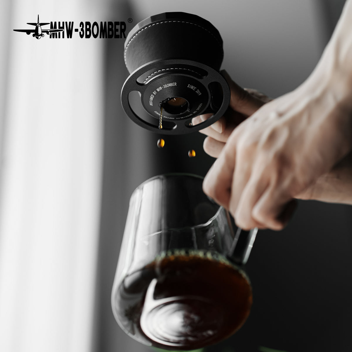 MHW-3BOMBER Meteorite Dripper FC6555B, Obsidian Black, underside and outlet held above a server; server is a prop
