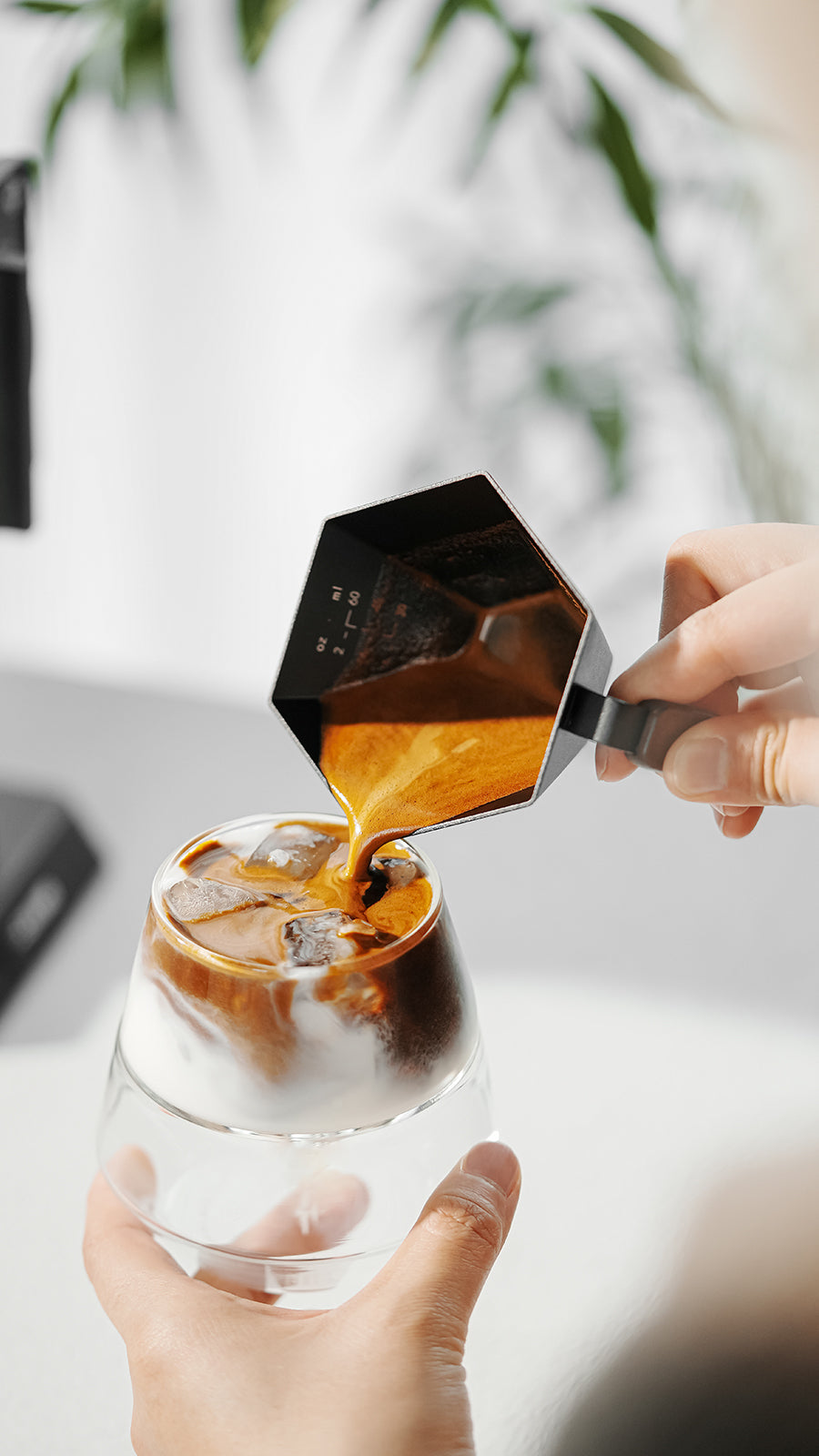 MHW-3BOMBER Black Prism cup pouring espresso into a separate glass