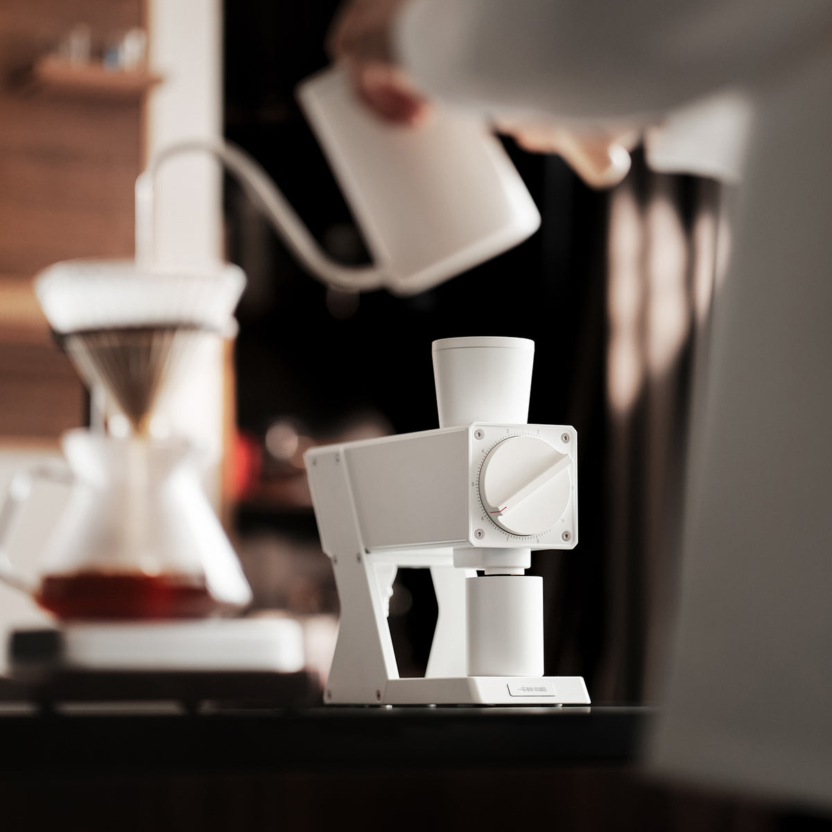 White F74 Navigator grinder with beans being poured into its hopper from a side view.