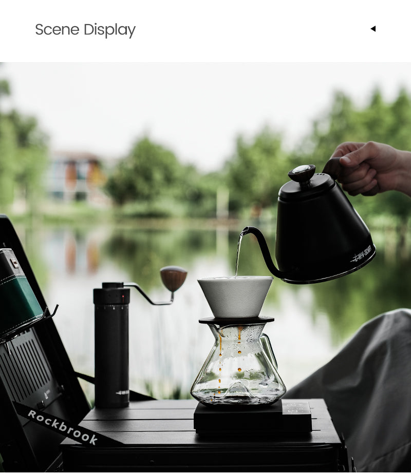 MHW-3BOMBER clear Hill coffee server beneath a dripper beside a window