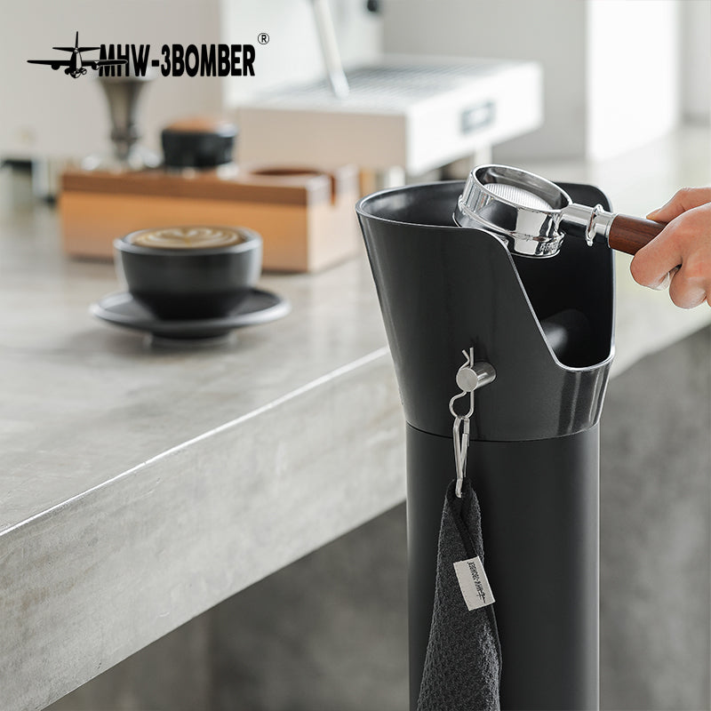 Bottomless portafilter held above the GB5449 bin beside a coffee counter