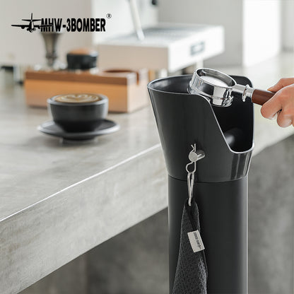 Bottomless portafilter held above the GB5449 bin beside a coffee counter