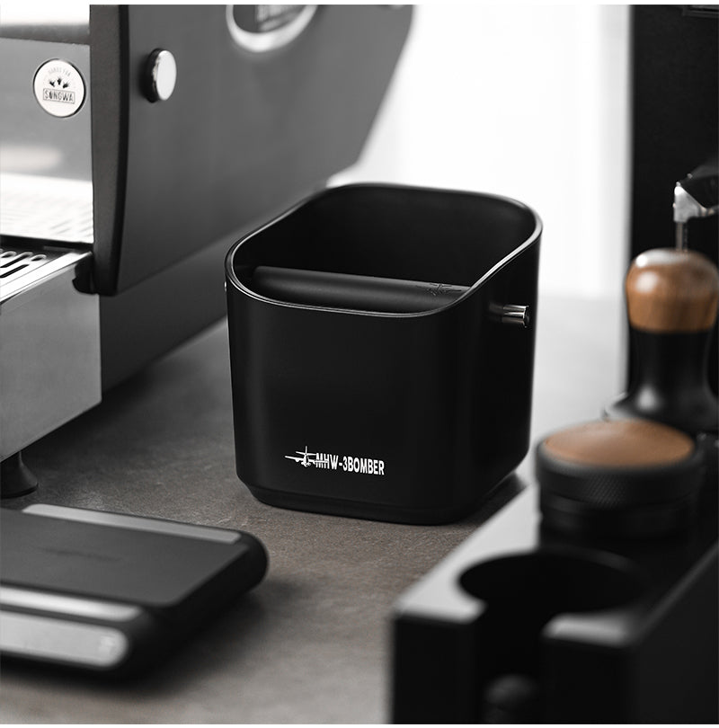 MHW-3BOMBER black square knock box standing on a coffee counter