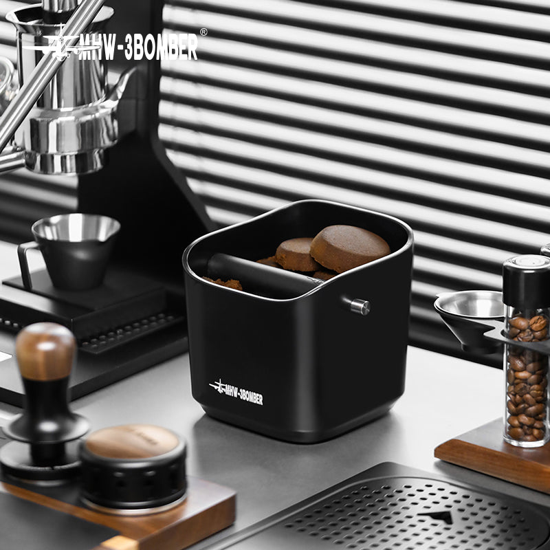 MHW-3BOMBER black knock box holding spent pucks beside a machine; machine separate