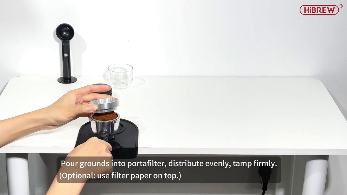 HiBREW H5A portafilter basket prepared with ground coffee; extra barista tools shown are separate.