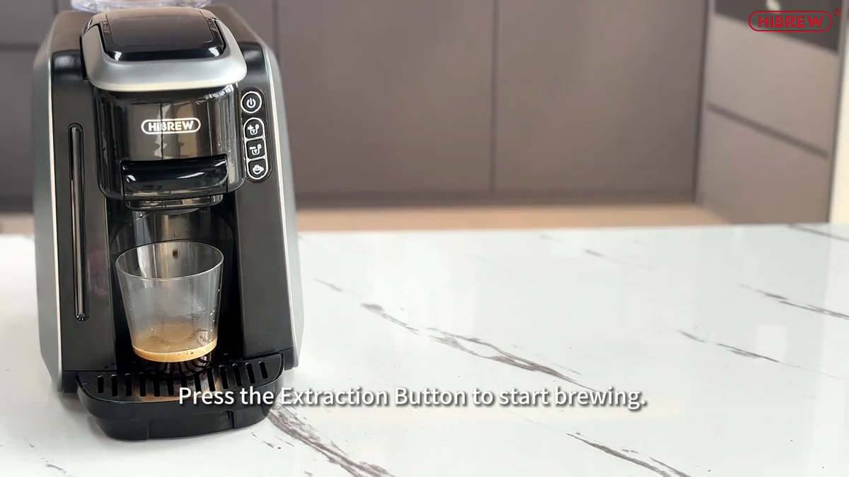 HiBREW H6 preparing coffee into a glass; cup and coffee capsules are separate.