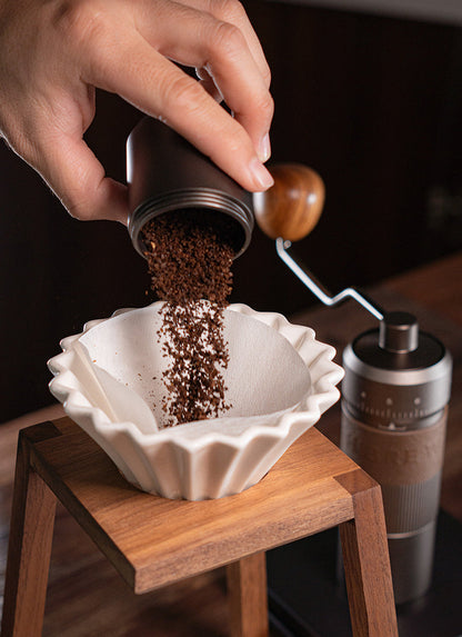 HiBREW G4B — Ground coffee poured from the grinder cup into a paper filter