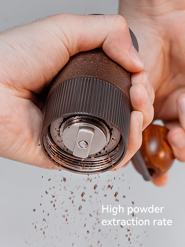 HiBREW G4B held in a hand showing the underside and burr access; manufacturer detail photo
