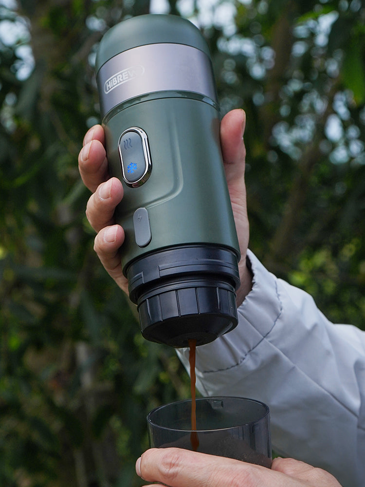Green HiBREW H4B being held during coffee preparation