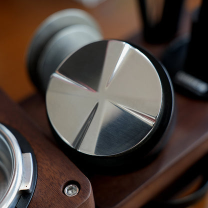 HiBREW Master 58mm distributor four-blade steel underside resting on a wood station. Portafilter and station are demonstration props, not included.