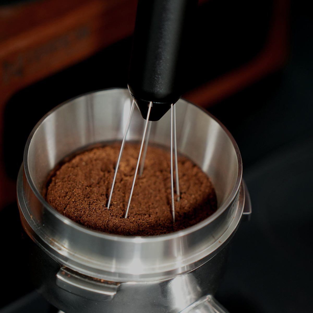 HiBREW Master WDT extended needles in coffee grounds, close view from above. Basket and station are demonstration props, not included.