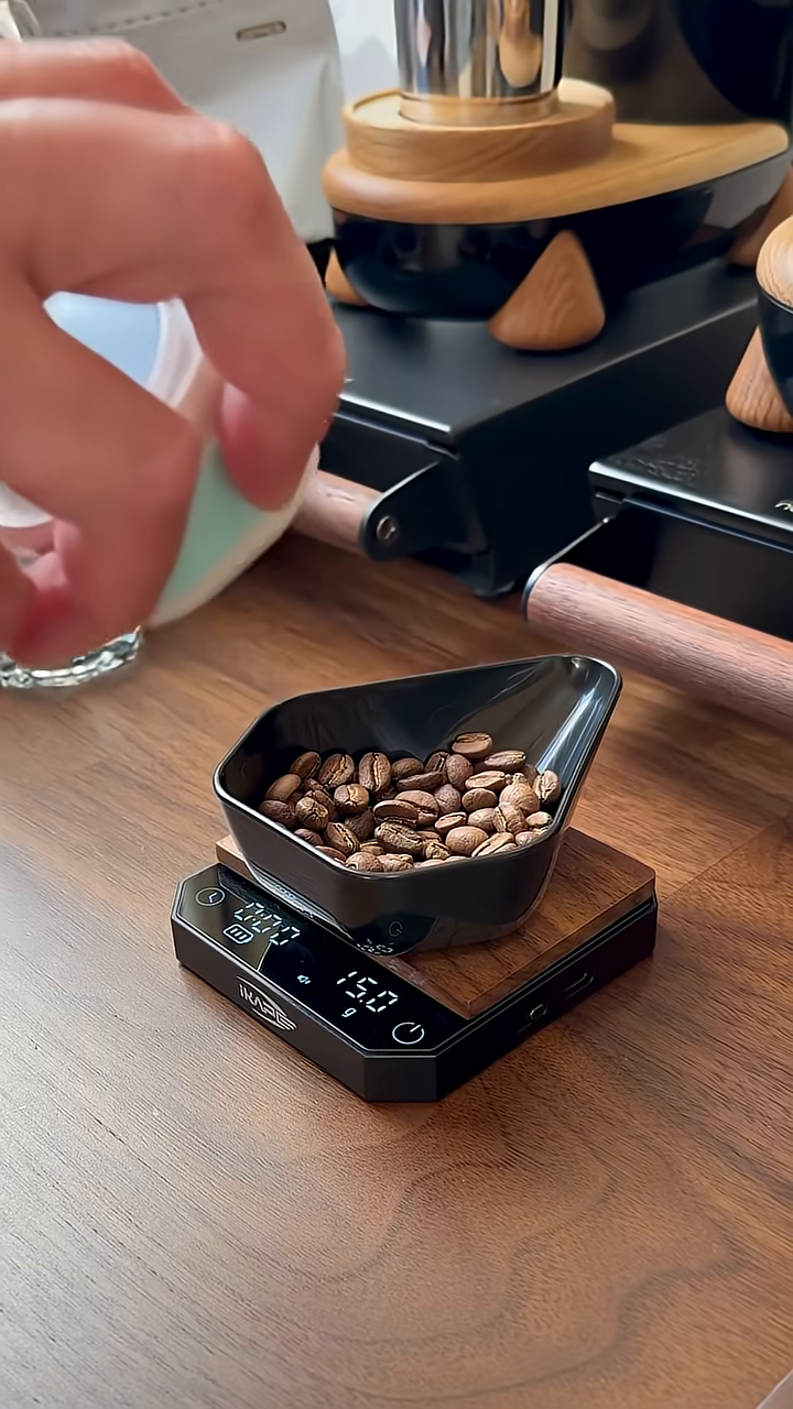IKAPE white and blue electric coffee bean atomizer, applying a light mist to coffee beans