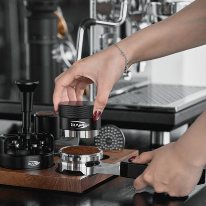 IKAPE Polaris black 58mm dual-ear flat-base bottomless portafilter; manufacturer scene 4; other equipment not included