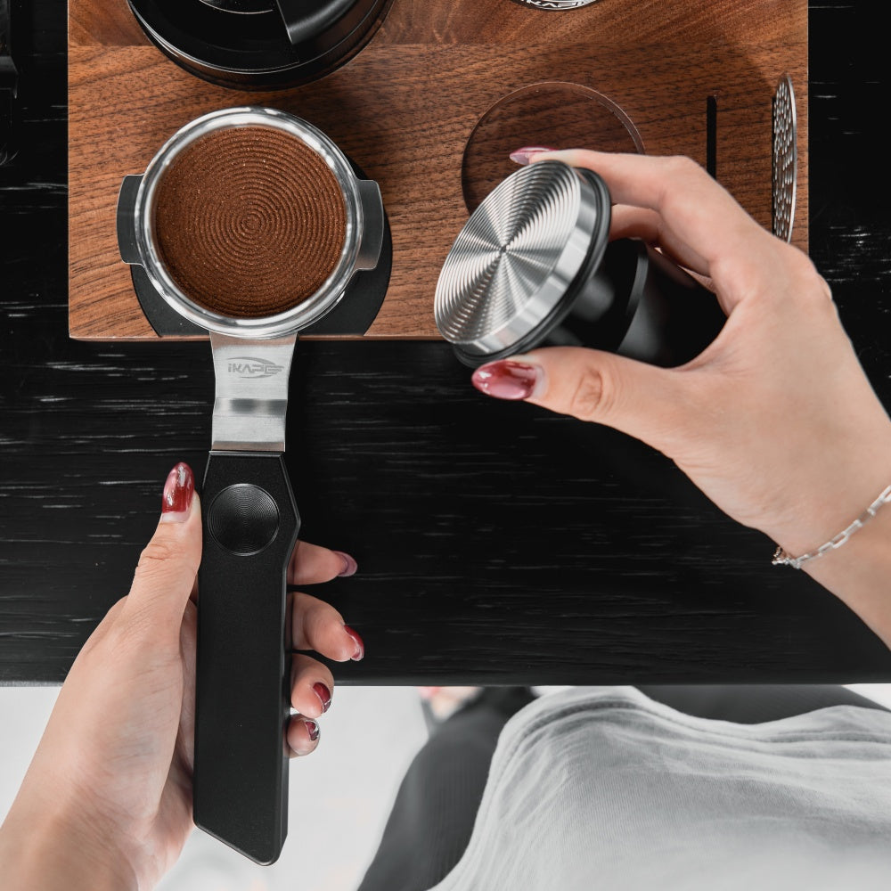 IKAPE Polaris black 58mm dual-ear flat-base bottomless portafilter; manufacturer scene 5; other equipment not included