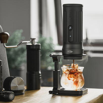 IKAPE folding stand supporting a portable espresso maker above an iced coffee glass