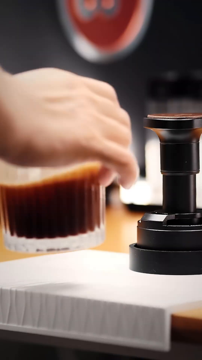 IKAPE UniPress 58.35 mm beside a freshly brewed espresso; cup sold separately.