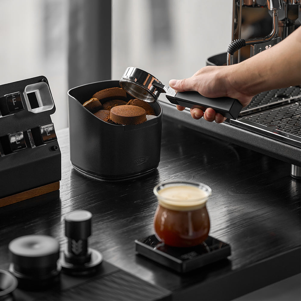 IKAPE V2 black knock box in a coffee preparation scene; other tools excluded