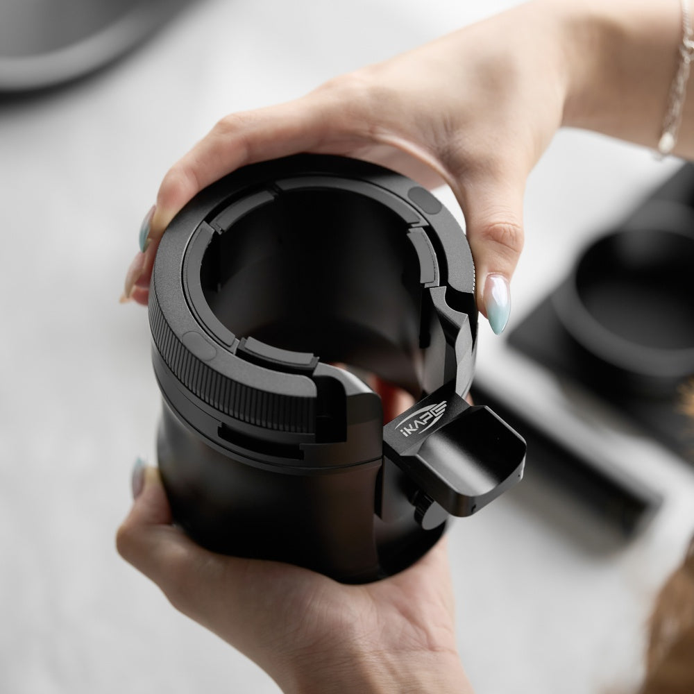 IKAPE V4 black rotary adjustable portafilter stand, manufacturer usage photograph 1; shown portafilter and preparation tools are props