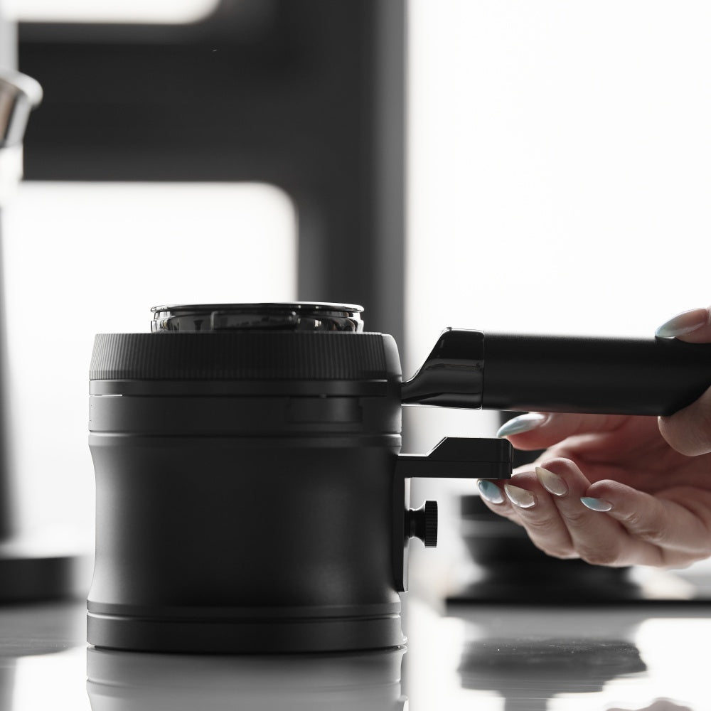 IKAPE V4 black rotary adjustable portafilter stand, manufacturer usage photograph 2; shown portafilter and preparation tools are props