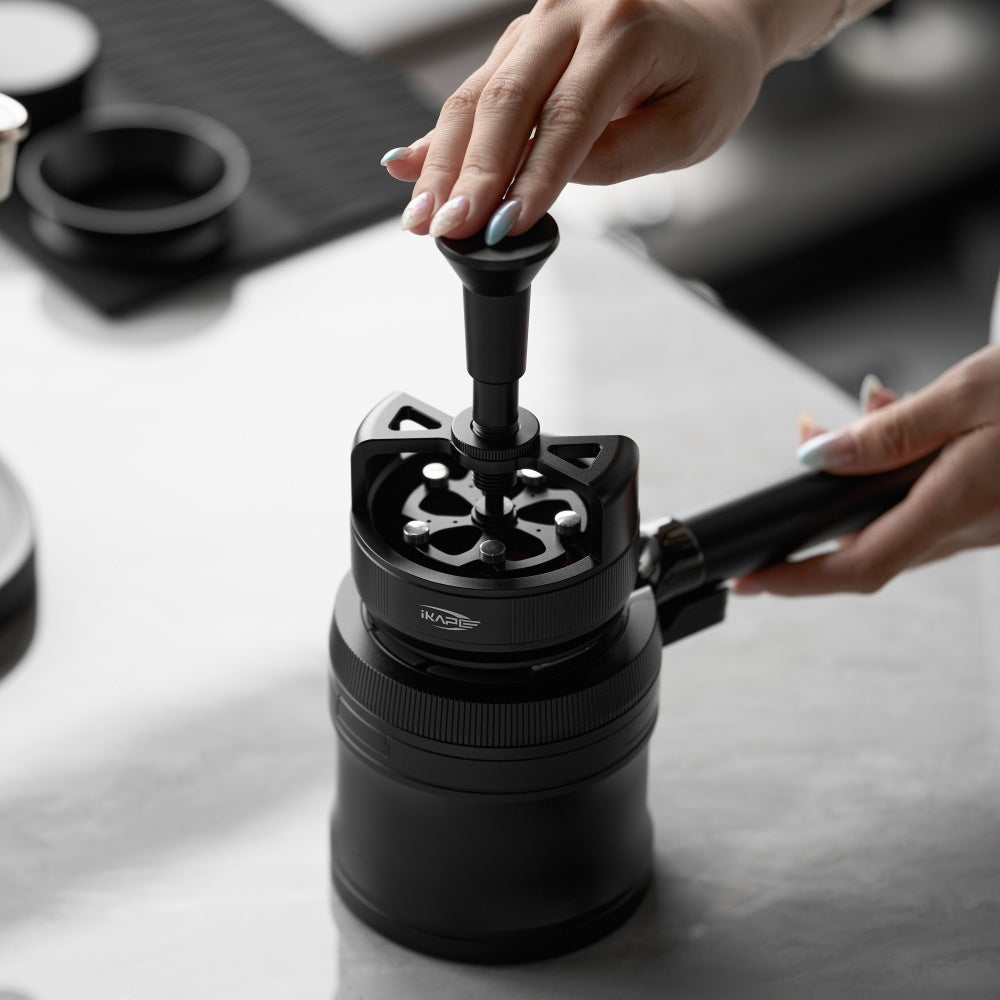 IKAPE V4 black rotary adjustable portafilter stand, manufacturer usage photograph 5; shown portafilter and preparation tools are props