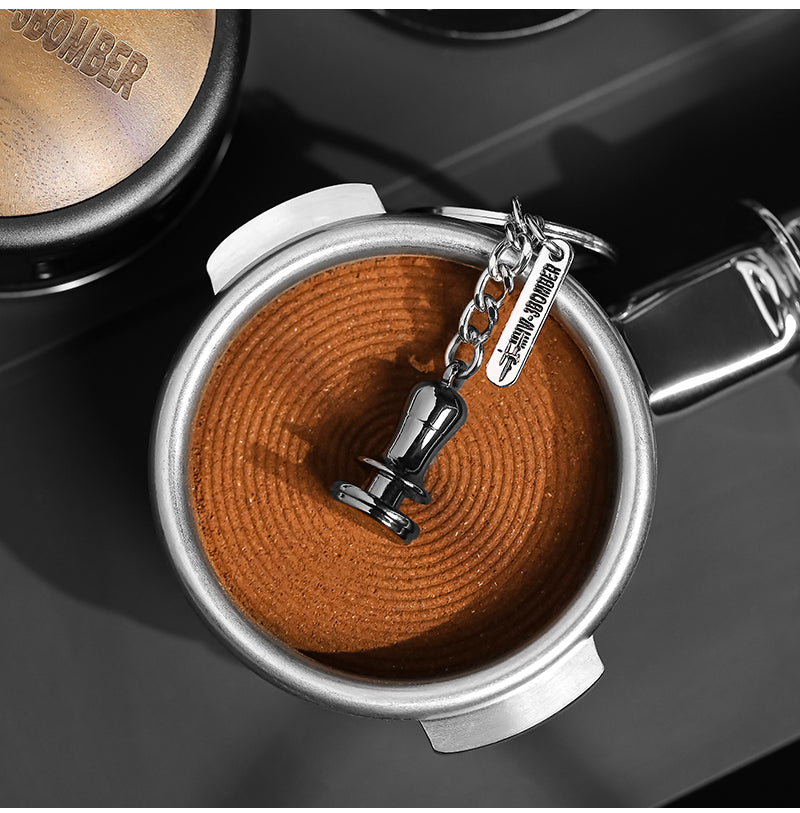 KC5701 miniature tamper keychain resting on a coffee puck; it is a decorative keychain, not a working tamper